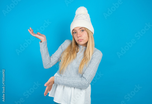 beautiful caucasian teen girl  pointing aside with both hands showing something strange and saying: I don't know what is this. Advertisement concept.