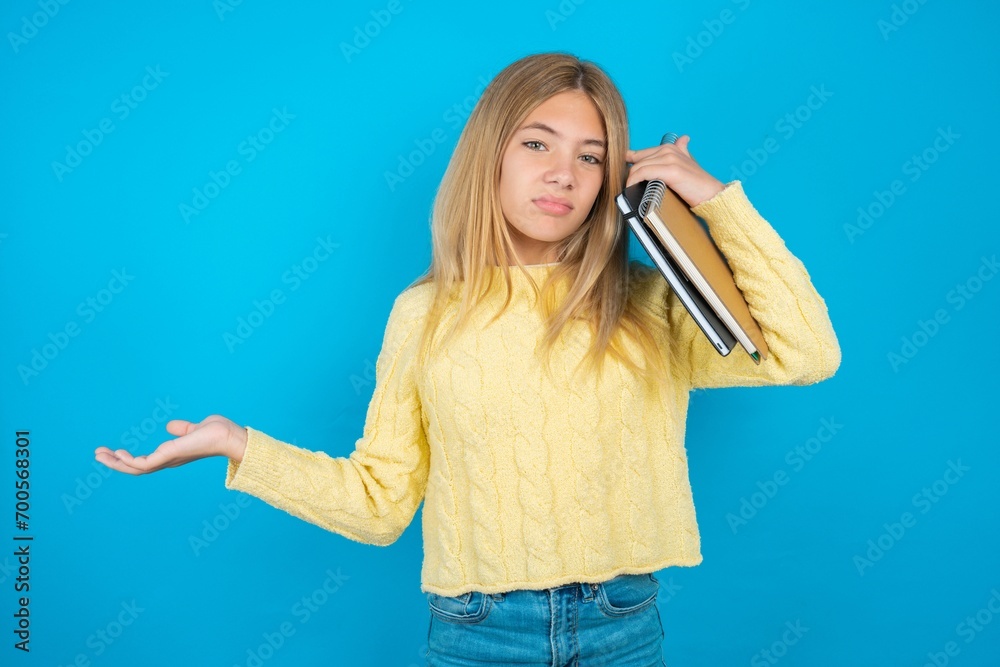 caucasian teen girl confused and annoyed with open palm showing copy space and pointing finger to forehead. Think about it. caucasian teen girl confused and annoyed with open palm showing copy space and pointing finger to forehead. Think about it.