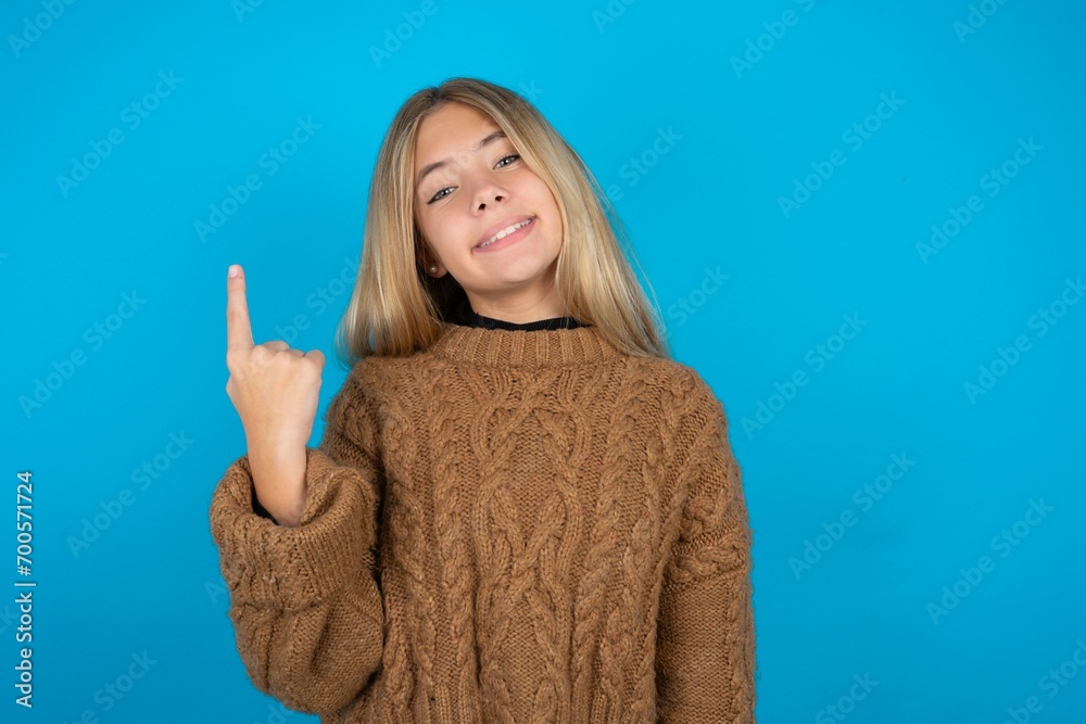 beautiful teen girl smiling and looking friendly, showing number one or first with hand forward, counting down beautiful teen girl smiling and looking friendly, showing number one or first with hand forward, counting down