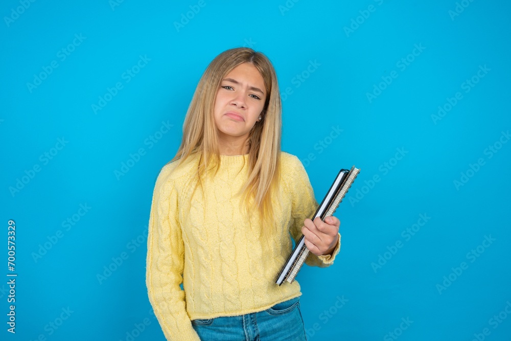 beautiful caucasian teen girl wearing yellow sweater depressed and worry for distress, crying angry and afraid. Sad expression. beautiful caucasian teen girl wearing yellow sweater depressed and worry for distress, crying angry and afraid. Sad expression.