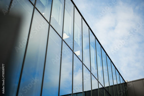 Beautiful glass panels on a business building showing reflections of the sky.