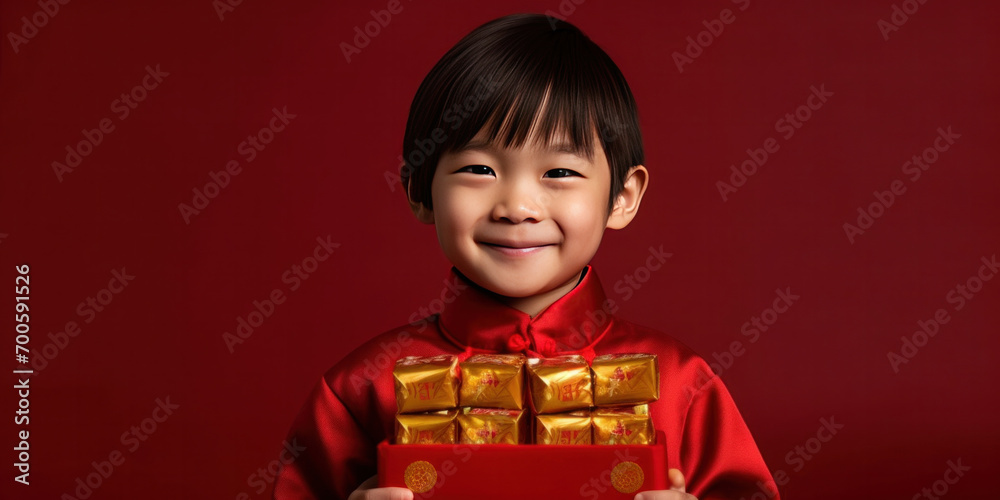 Asian cute boy holding angpao or red packet monetary gift and gold ingot isolated on red background. Happy Chinese new year. Asian cute boy holding angpao or red packet monetary gift and gold ingot isolated on red background. Happy Chinese new year.