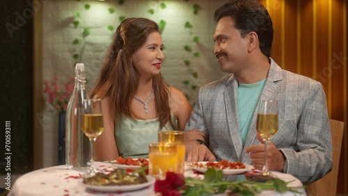 joyful romantic Indian couples spending time together during candlelight dinner at restaurant - concept of relationship closeness and date night affection