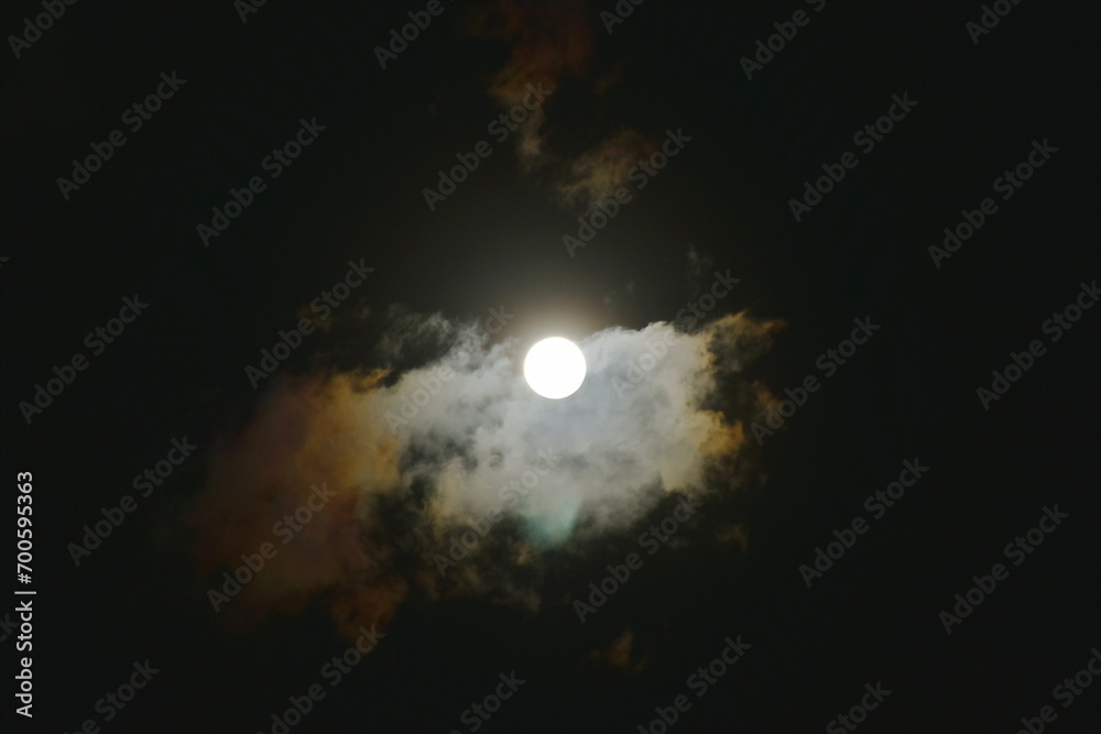 full moon covering by cloud  arranging on sky in night 