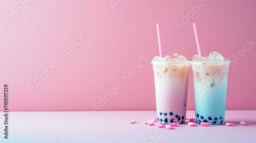 Plastic clear glass with delicious milk tea with tapioca balls. Milk bobba cold tea, summer drink on flat pink background with copy space, banner template. photo