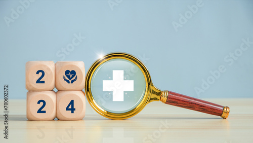 Happy New Year 2024 health goal, medical and healthcare priority concept. Wooden cubes with Text 2024 and Magnifying glass with medical icon. health insurance concept, new year resolutions goal.