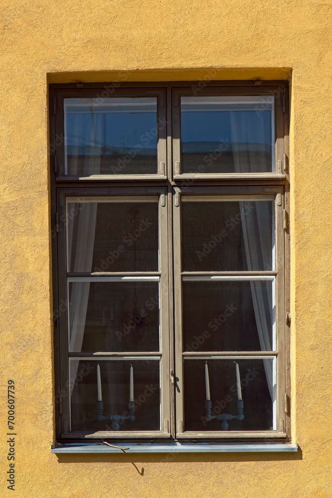 Brown framed window a yellow building. Brown framed window a yellow building.