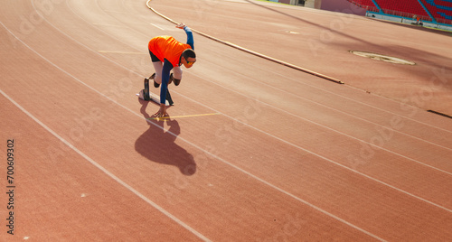 Asian para-athlete runner prosthetic leg on the track alone outside on a stadium track Paralympic running concept. © Hip.hub