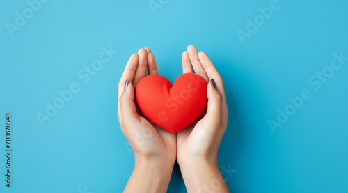 The essence of love with hands presenting a red heart on a serene blue background, an eloquent symbol of affection. Generative AI.