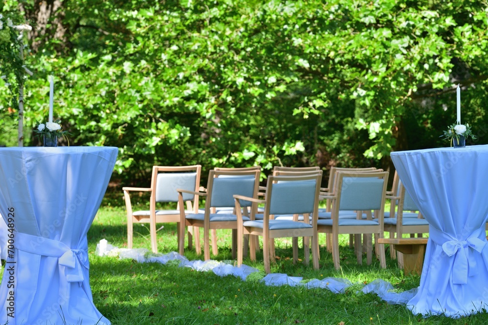White decorated wedding chairs for guests in a garden park for a wedding