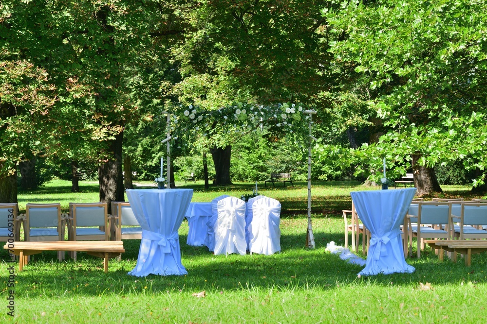 Modern wedding in a garden park and white decoration of the altar and chairs for guests
