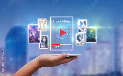 Short Video marketing concept.Man hands holding mobie phone short video player with blurred city as background photo