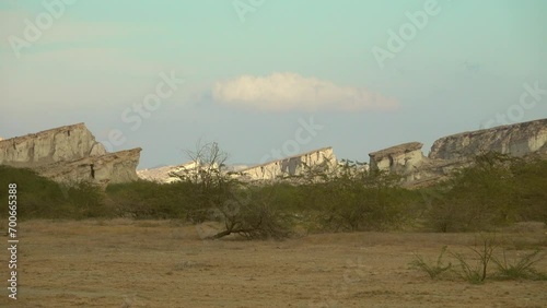 Geology. Panorama inside deserted volcanic island of Hormuz, Iran. Flat remnants of calcareous deposits (oblique tablemounts, upturned strata of mantle rock) and acacia thickets, shrub, semidesert photo