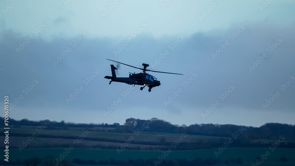 British army Boeing Apache Attack helicopter gunship (AH64E AH-64E ArmyAir606) in low level flight, Wiltshire UK British army Boeing Apache Attack helicopter gunship (AH64E AH-64E ArmyAir606) in low level flight, Wiltshire UK