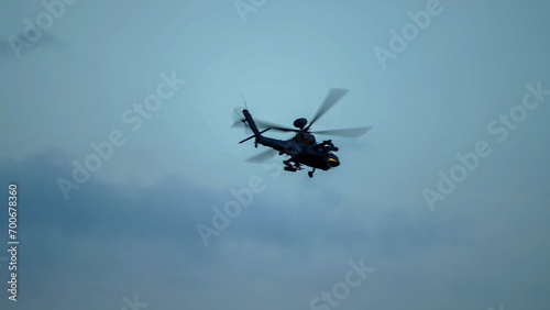 British army Boeing Apache Attack helicopter gunship (AH64E AH-64E ArmyAir606) banking hard in flight, Wiltshire UK