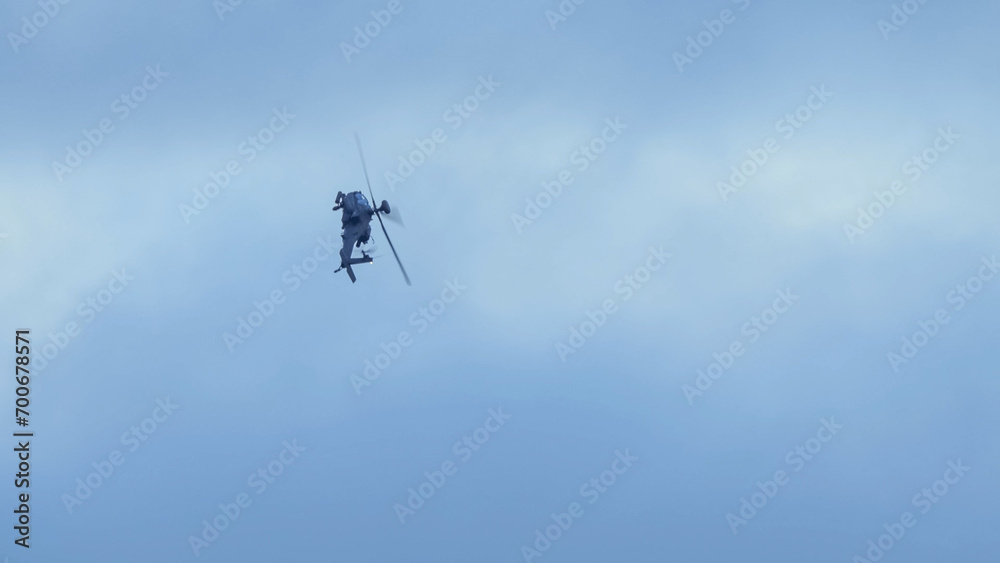 close-up of a British army Boeing Apache Attack helicopter gunship AH64E (AH-64E ArmyAir606) at full bank in a hammerhead stall turn, Wiltshire UK close-up of a British army Boeing Apache Attack helicopter gunship AH64E (AH-64E ArmyAir606) at full bank in a hammerhead stall turn, Wiltshire UK