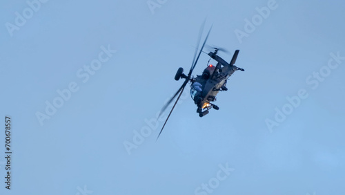 Fototapeta Naklejka Na Ścianę i Meble -  close-up of a British army Boeing Apache Attack helicopter gunship AH64E (AH-64E ArmyAir606) at full bank in a hammerhead stall turn, Wiltshire UK