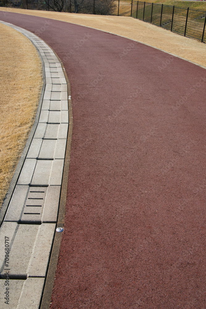Fototapeta premium 冬の公園の地面と芝生を分ける雨水の側溝