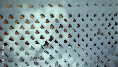 Horizontal pattern background of snow patterns on a metal grid with sun light photo