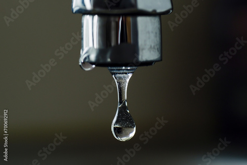 Faucet with drop of water, close up of water drop