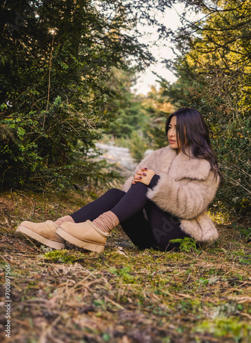 Stylish woman sitting with a beautiful forest in the background    