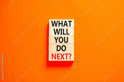 What will you do next symbol. Concept words What will you do next on wooden blocks. Beautiful orange table orange background. Business, what will you do next concept. Copy space. photo