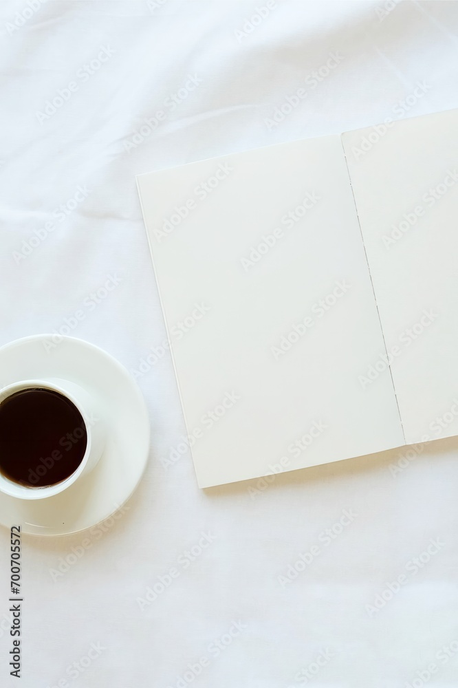 Opened note and coffee cup on a white sheet. Cozy composition on a bed Opened note and coffee cup on a white sheet. Cozy composition on a bed