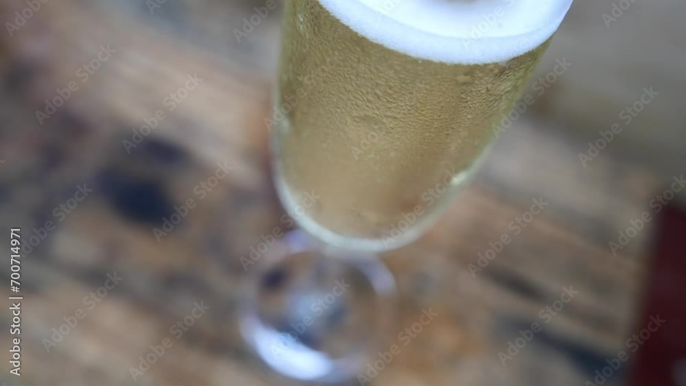 Bubbles rising intensely: a very bubbly glass of champagne on the table, close-up. Glass of sparkling wine. Bubbly sparkling wine flute. A bubbly champagne flute. Champagne glass bubbles. Drinking day