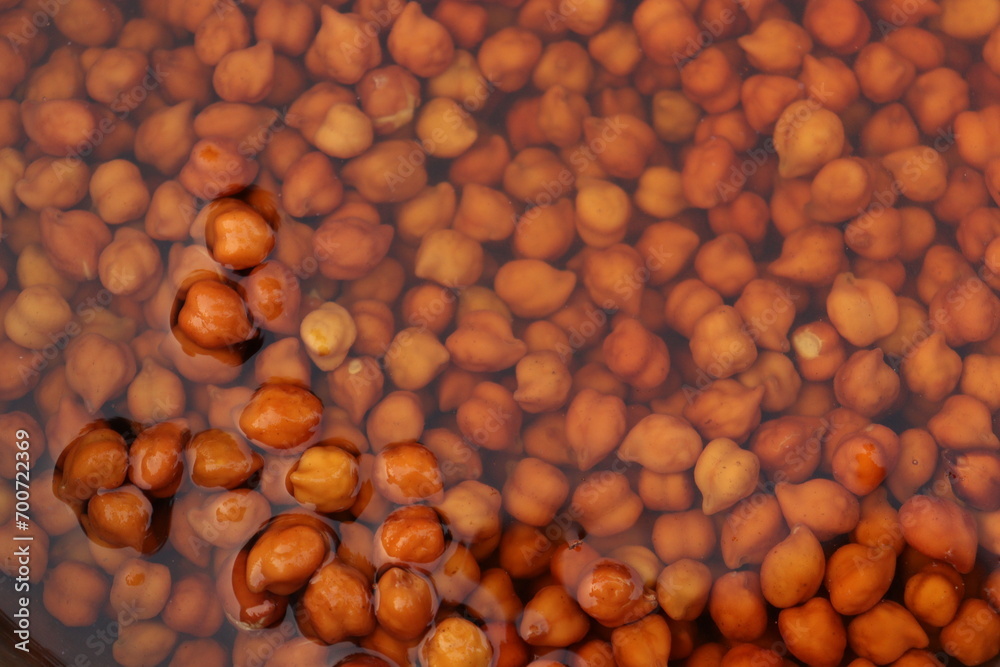 Brown Chickpea or channa soaked in water in a steel vessel or bartan, in water Brown Chickpea or channa soaked in water in a steel vessel or bartan, in water