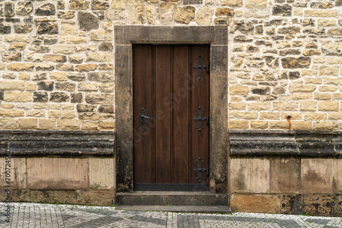 The door of a medieval gothic building made out of wood and metal.