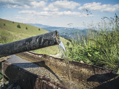 Water spring with crystal clear mountain water in the alps. Alpine water source. photo