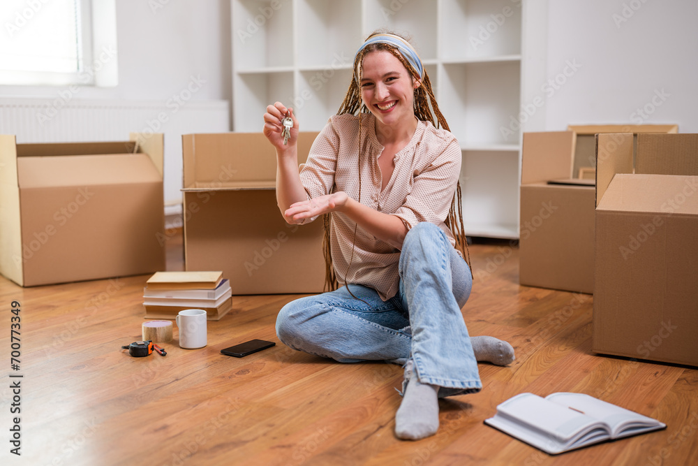 Modern ginger woman with braids showing key of her new home. Modern ginger woman with braids showing key of her new home.
