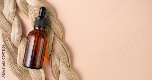 Hair serum. A vial with serum lies on blond hair. Hair treatment.