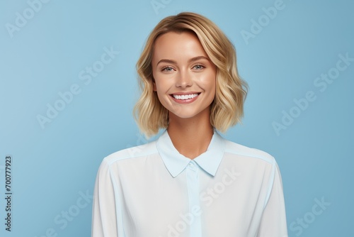 Cute woman with perfect smile on blue background photo