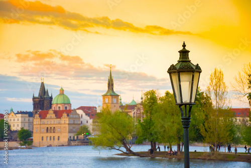 Blurred view of Strelecky island on Vltava river and old town of Prague, Czech Republic, at sunset. Selective focus on the street light photo