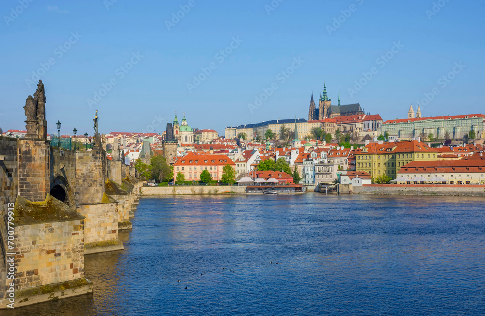 Famous Charles Bridge on Vltava River with Hradcany castle and St. Vitus Cathedral in Prague, Czech Republic, in sunny day