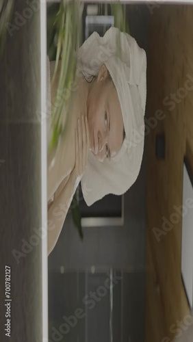 Caucasian female in her 40s is making her daily skin care routine