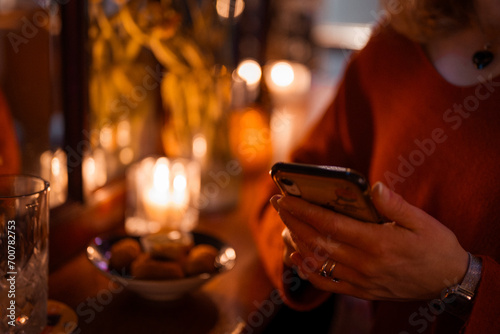 Person with smartphone in restaurant.