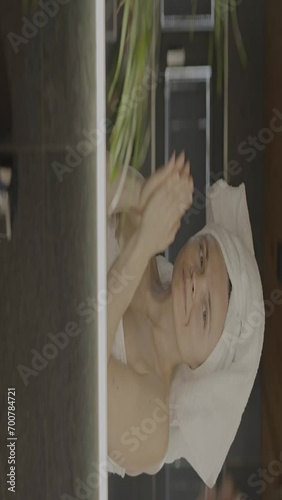 Caucasian female in her 40s is making her daily skin care routine