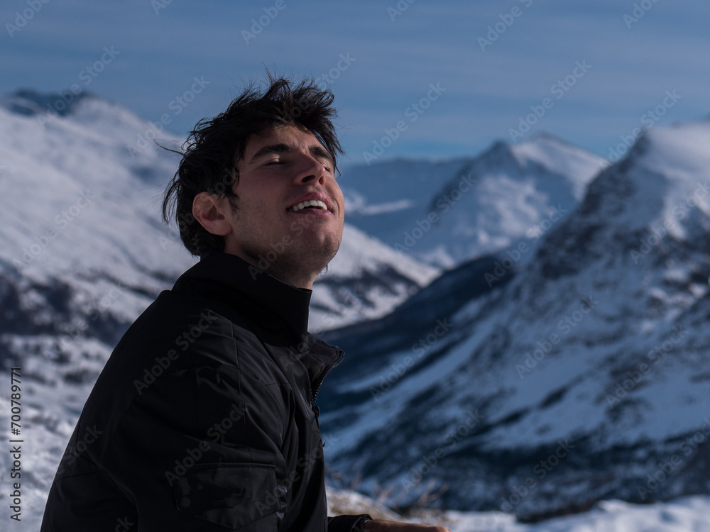 A man sitting on top of a snow covered mountain