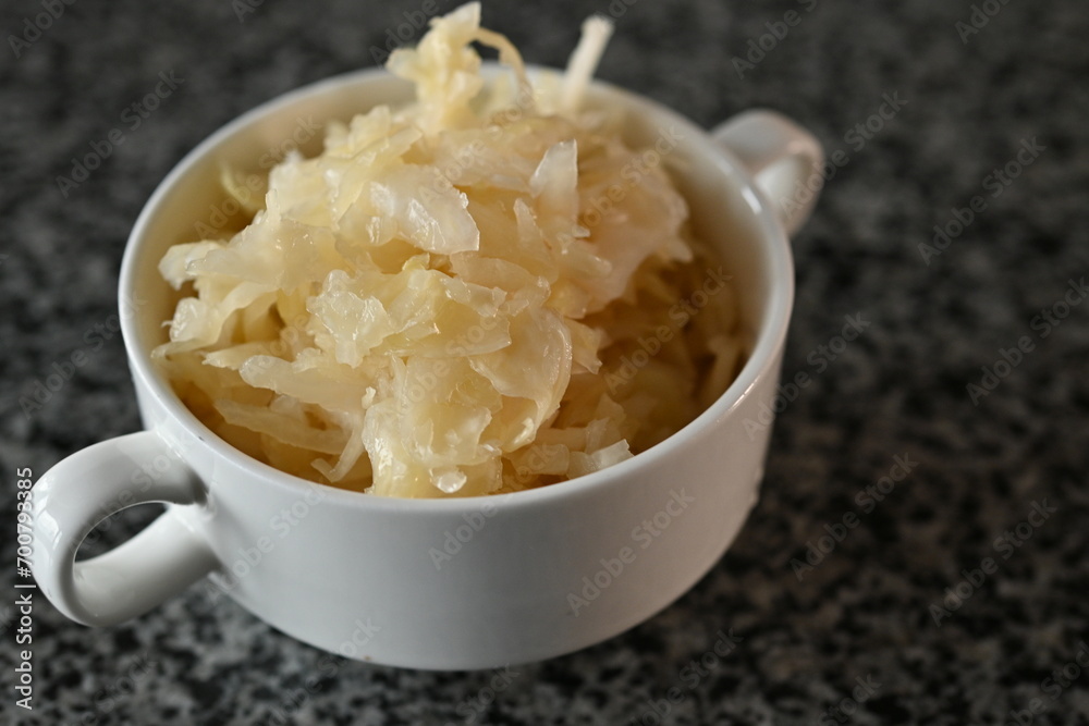 fermented cabbage, fermented white cabbage in a white plate on a gray background fermented cabbage, fermented white cabbage in a white plate on a gray background