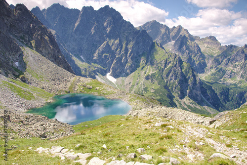 Widok w Dolinie Białej Wody na jezioro Litworowy Staw wysokogórski ukazujący szczyty w Tatrach podobne do Alp.