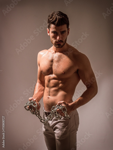 Photo of a shirtless man wearing a chain necklace