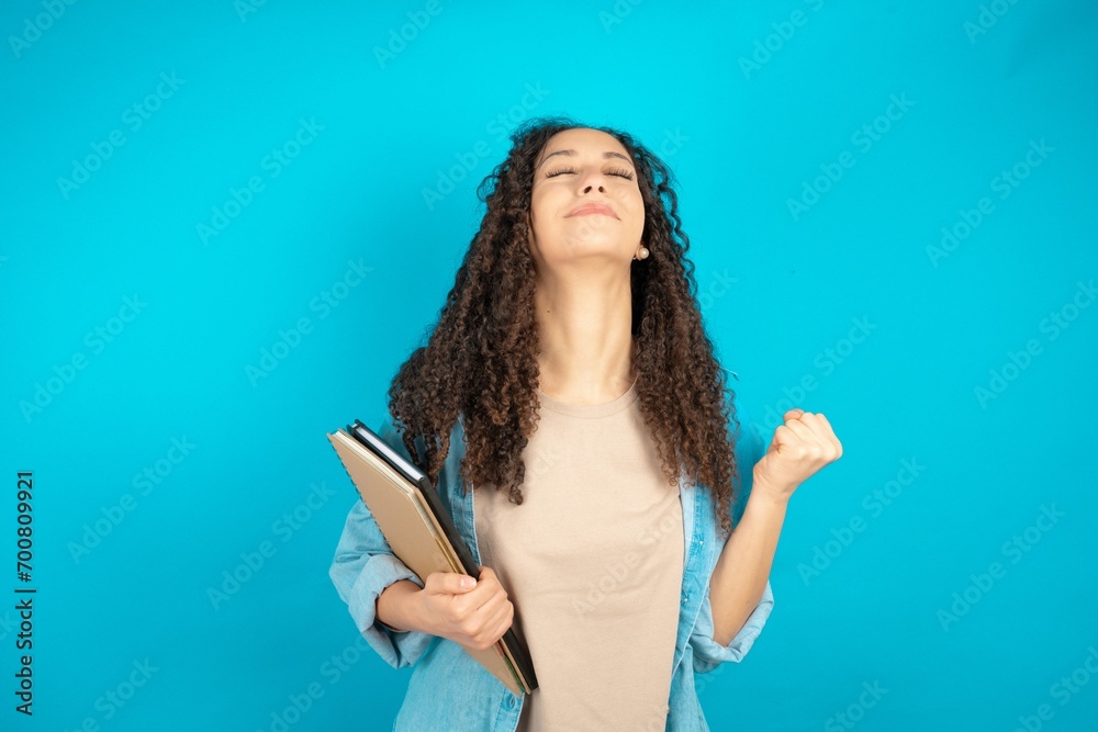 beautiful teen girl celebrating surprised and amazed for success with arms raised and open eyes. Winner concept. beautiful teen girl celebrating surprised and amazed for success with arms raised and open eyes. Winner concept.