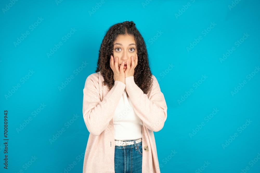 Stupefied beautiful teen girl expresses excitement and thrill, keeps jaw dropped, hands on cheeks, has eyes popped out Stupefied beautiful teen girl expresses excitement and thrill, keeps jaw dropped, hands on cheeks, has eyes popped out
