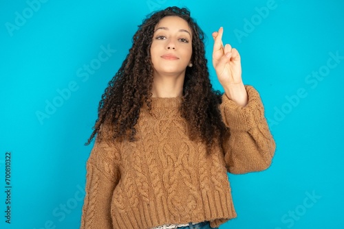 beautiful teen girl wearing brown knitted sweater pointing up with fingers number ten in Chinese sign language Shi photo