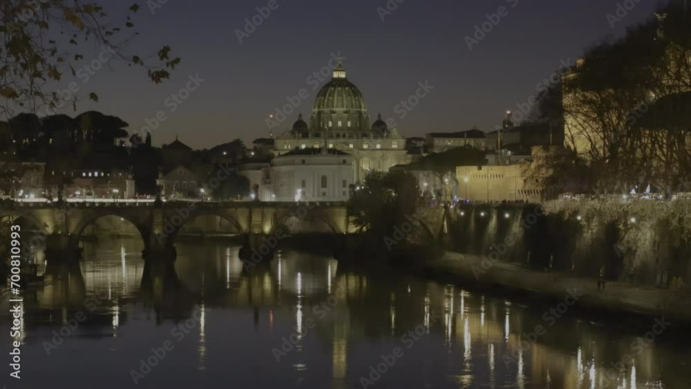 Stunning night view of the Sant'Angelo bridge and St. Peter's Basilica illuminated in the evening during the Christmas period, with the Tiber river in the foreground. Stunning night view of the Sant'Angelo bridge and St. Peter's Basilica illuminated in the evening during the Christmas period, with the Tiber river in the foreground.