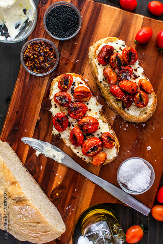 Mascarpone Toast with Burst Tomatoes: Slices of crusty bread topped with creamy cheese, charred grape tomatoes, and extra virgin olive oil photo