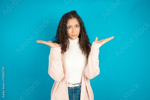 Indignant Beautibul teen girl wearing casual clothes gestures in bewilderment, frowns face with dissatisfaction. photo