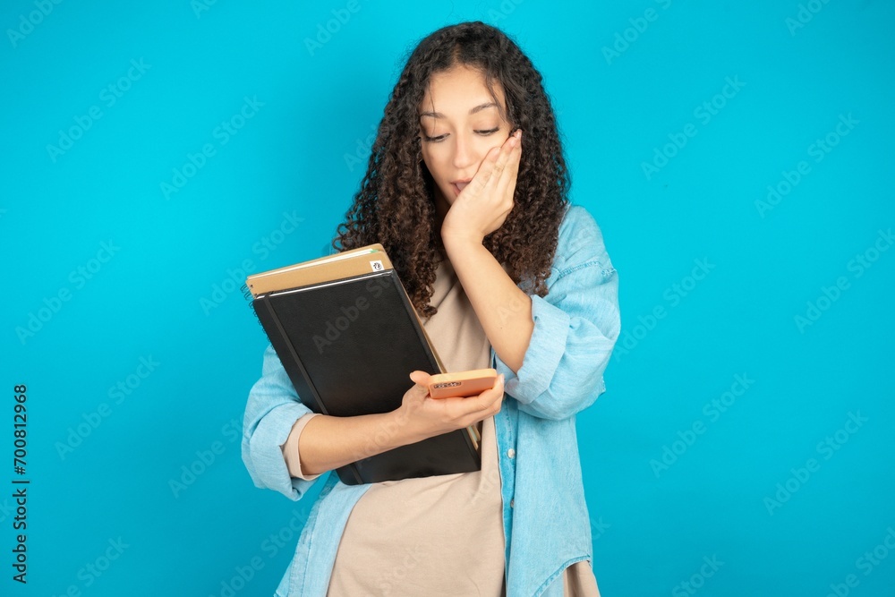 beautiful arab student carries notebooks holding in hands cell reading sms using new app 5g beautiful arab student carries notebooks holding in hands cell reading sms using new app 5g